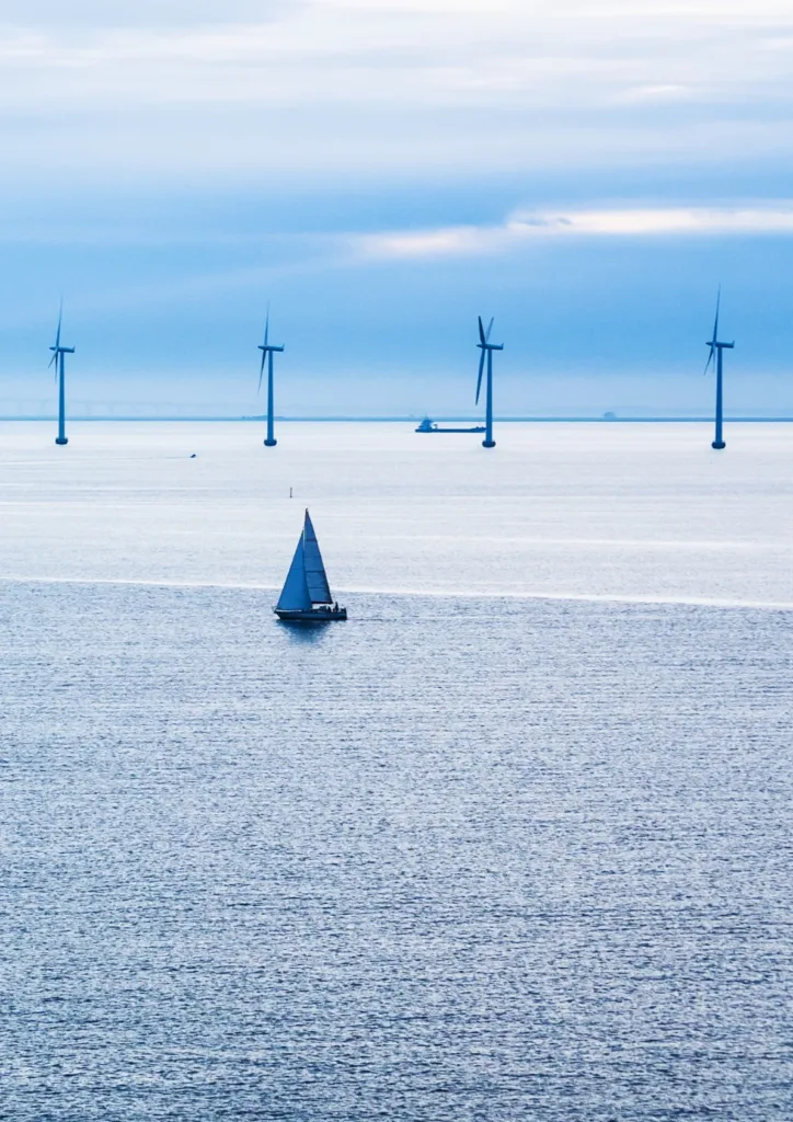Sailboat passing an offshore wind farm